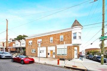 Philadelphia apartment for rent - A red sports car is parked on the street in front of a brick building.