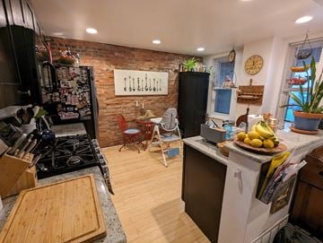 Philadelphia apartment for rent - A kitchen with a white stove top oven and a black fridge.