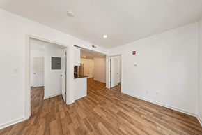 Philadelphia apartment for rent - A room with white walls and wooden flooring with a doorway leading to another room.