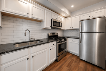 Philadelphia apartment for rent - A modern kitchen with white cabinets and stainless steel appliances.