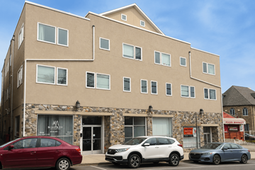 Philadelphia apartment for rent - A building with a stone facade and three cars parked in front.