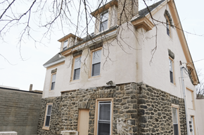 Philadelphia apartment for rent - an old stone house with windows and a tree