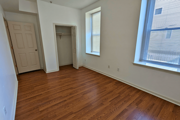 Philadelphia apartment for rent - a bedroom with wood flooring and a closet and a window