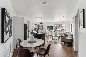 Philadelphia apartment for rent - A modern dining room with a white table and brown chairs.