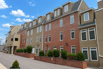 Philadelphia apartment for rent - A row of red brick houses with white windows and black roofs.