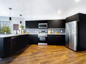 Philadelphia apartment for rent - A modern kitchen with black cabinets and a wooden floor.