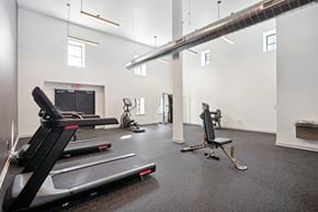 Philadelphia apartment for rent - the gym with treadmills and other exercise equipment in a room with a fireplace