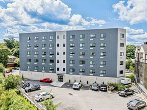 Philadelphia apartment for rent - a large gray building with cars parked in a parking lot