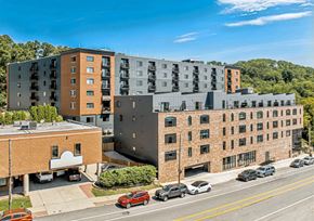 Philadelphia apartment for rent - A street view of a residential area with cars parked on the side of the road and multi-story buildings in the background.