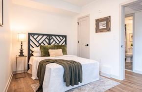 Philadelphia apartment for rent - A bedroom with a white bed and a green throw blanket.