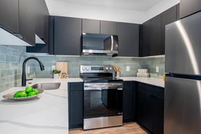 Philadelphia apartment for rent - A modern kitchen with black cabinets and stainless steel appliances.