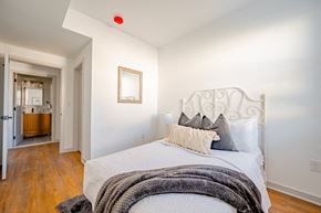 Philadelphia apartment for rent - A bedroom with a white bed and a red light on the ceiling.