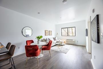Philadelphia apartment for rent - a living room with white walls and a white couch and red chairs
