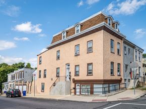 Philadelphia apartment for rent - A large brick building with a brown roof and a garage door on the ground floor.