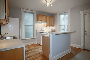 Chicago apartment for rent - an empty kitchen with white appliances and wooden cabinets
