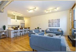 Chicago apartment for rent - a living room and kitchen with blue couches and a table