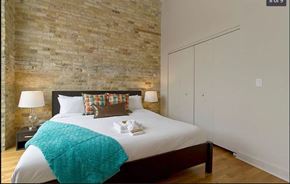 Chicago apartment for rent - a bedroom with a bed and a brick wall
