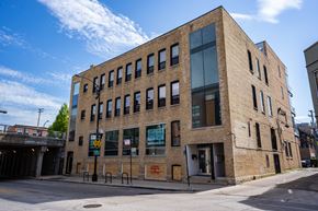 Chicago apartment for rent - a brick building on a city street with a bridge