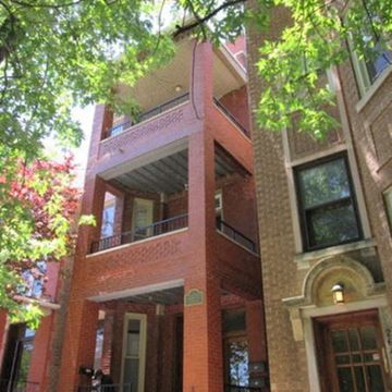 Chicago apartment for rent - a tall brick building with a balcony and a