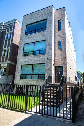 Chicago apartment for rent - a building with a stairway and a fence in front of it