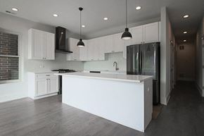 Chicago apartment for rent - a white kitchen with a large island and a stainless steel refrigerator