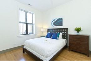 Chicago apartment for rent - a bedroom with a bed and a dresser and a window
