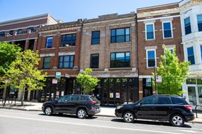 Chicago apartment for rent - a city street with cars parked in front of a brick building