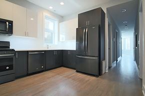 Chicago apartment for rent - an empty kitchen with black appliances and white cabinets