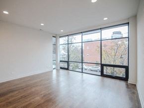 Chicago apartment for rent - an empty living room with a large window and wood floors