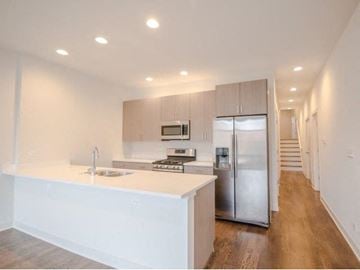 Chicago apartment for rent - a large white kitchen with a stainless steel refrigerator