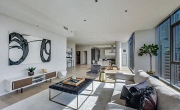 Chicago apartment for rent - A modern living room with a glass coffee table and a large window.