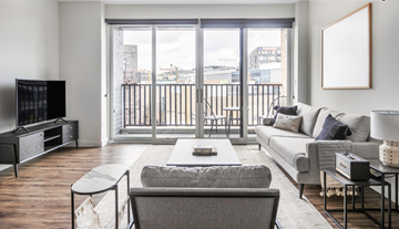 Chicago apartment for rent - a living room with a couch and a tv and a balcony