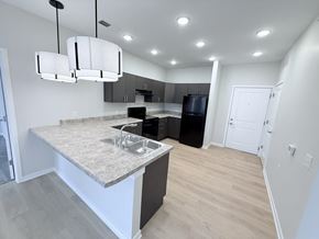 Indianapolis apartment for rent - A kitchen with a granite countertop and a black refrigerator.
