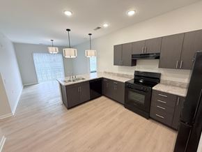 Indianapolis apartment for rent - A kitchen with black appliances and brown cabinets.