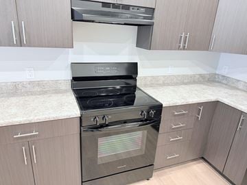 Indianapolis apartment for rent - A modern kitchen with a stove top oven and cabinets.