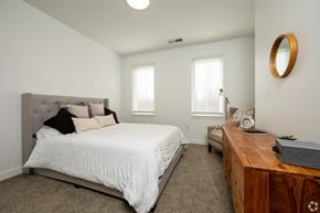 Plainfield apartment for rent - A bedroom with a large bed and a wooden desk.