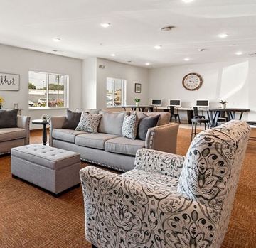Kokomo apartment for rent - A living room with a grey couch and a patterned armchair.