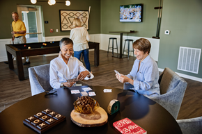 Westfield apartment for rent - Three people playing a board game in a room with a pool table.