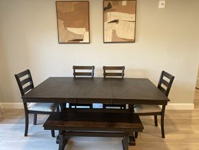 Laconia apartment for rent - a dining room table with chairs and two paintings on the wall