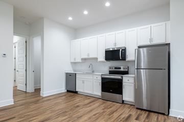 Inwood apartment for rent - A kitchen with white cabinets and stainless steel appliances.