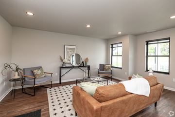 Ames townhouse for rent - A living room with a brown couch and a grey chair.