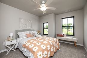 Ames townhouse for rent - A bedroom with a bed, bench, and window.