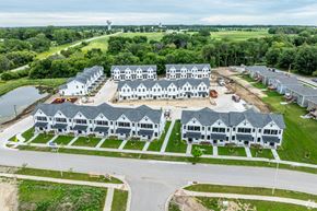 Ames townhouse for rent - A large, modern building complex with multiple white and grey buildings, surrounded by greenery and a body of water.