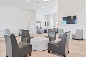 Howell apartment for rent - A modern living room with grey chairs and a white coffee table.