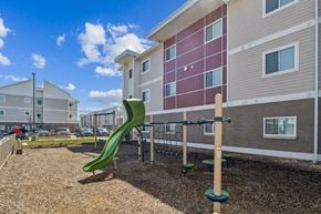 Indianapolis apartment for rent - A playground with a green slide in front of a building at Union at 16th, Indianapolis, IN