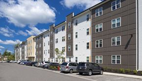 Bloomington apartment for rent - A row of modern apartment buildings with cars parked in front.at Union at Crescent, Bloomington, 47404
