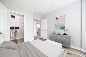 A white couch sits in a bright room with a grey sofa and a white dresser