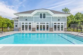 Newburgh apartment for rent - a swimming pool in front of a blue house with a pool