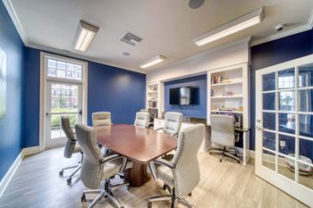A meeting room with a table and chairs