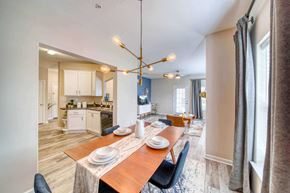 Suffolk apartment for rent - a dining area with a wooden table and chairs and a kitchen in the background at Meridian Obici, Suffolk, VA